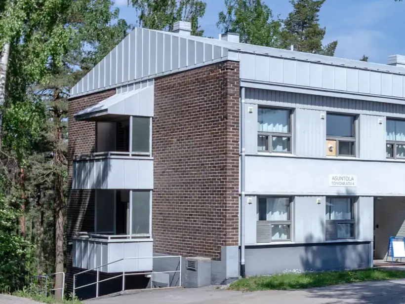 Kaksikerroksinen talo, jossa ruskea tiiliverhoilu sekä vaaleaa puuverhoilua.
