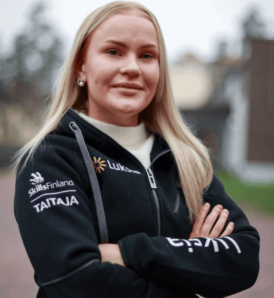 Vaaleahiuksinen henkilö mustassa hupparissa.