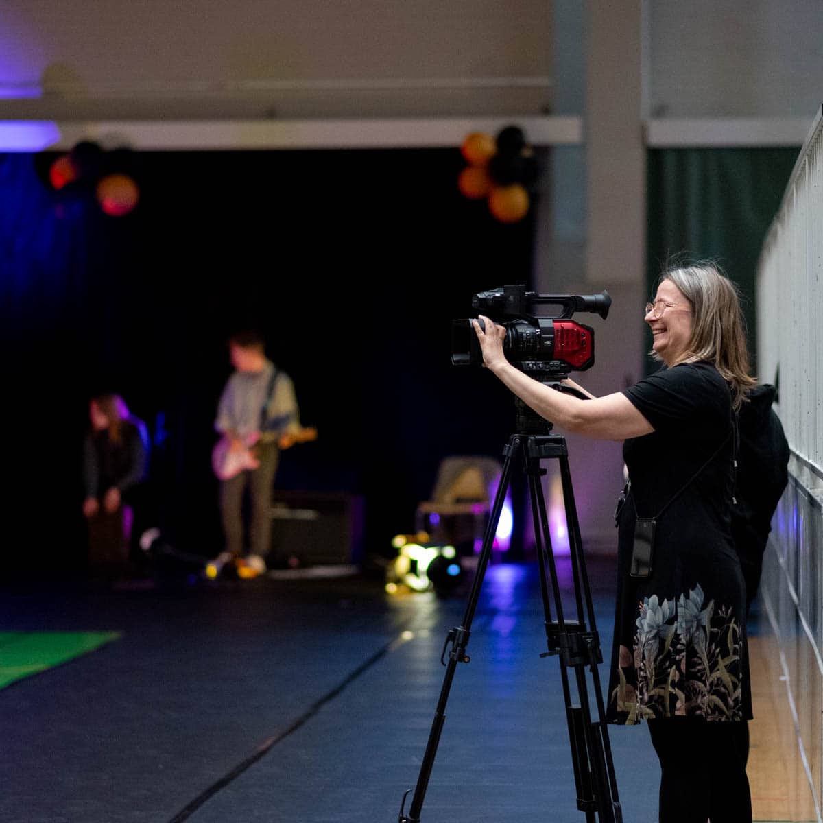 Ihminen kuvaa videokameralla, joka on jalustalla.