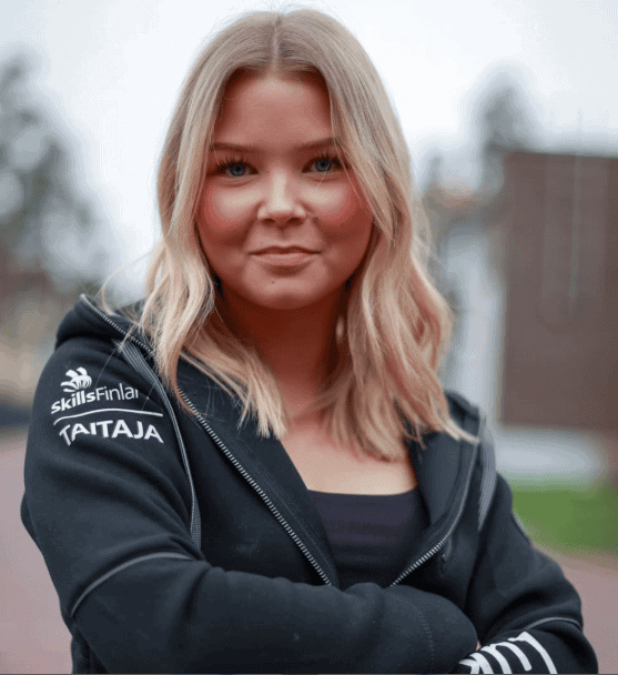 Vaaleahiuksinen henkilö mustassa hupparissa.