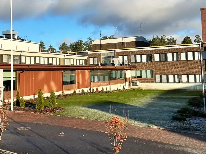 Ruskeatiilinen rakennus aurinkoisessa säässä.