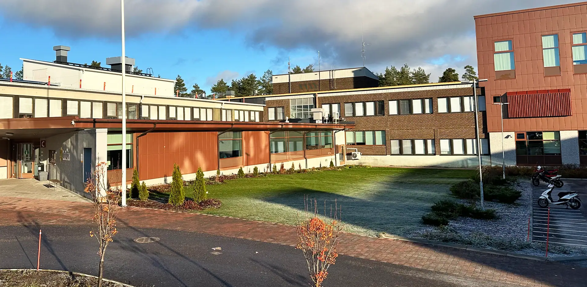 Ruskeatiilinen rakennus aurinkoisessa säässä.