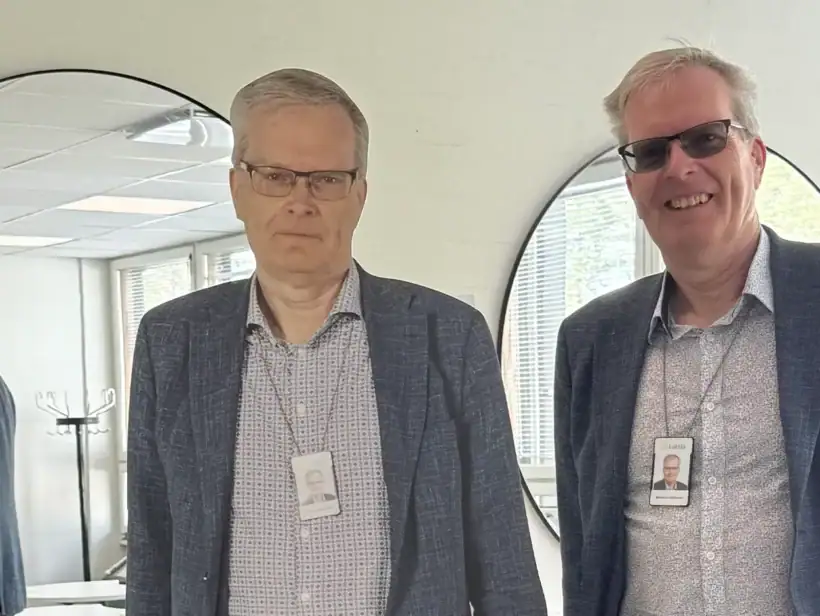 Henkilö sinisessä takissa, vierellään pahvihahmo hänestä.