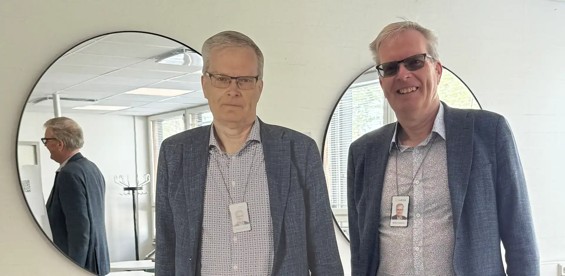 Henkilö sinisessä takissa, vierellään pahvihahmo hänestä.