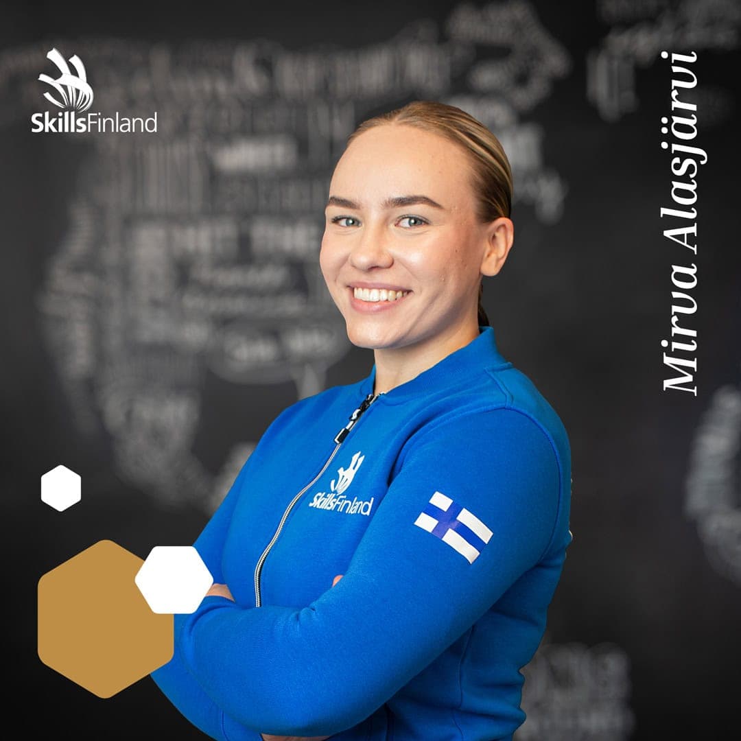 Henkilö hymyilee sininen edustusasu päällään.
