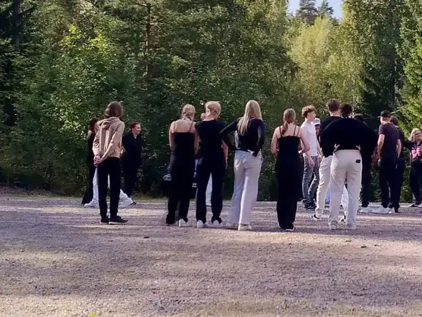 Nuoria kerääntyneenä yhteen mökkipihassa.