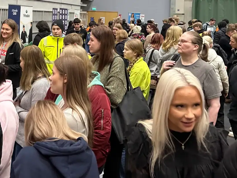 Liikuntasalissa on paljon ihmisiä, jotka tutustuvat eri työnantajiin.