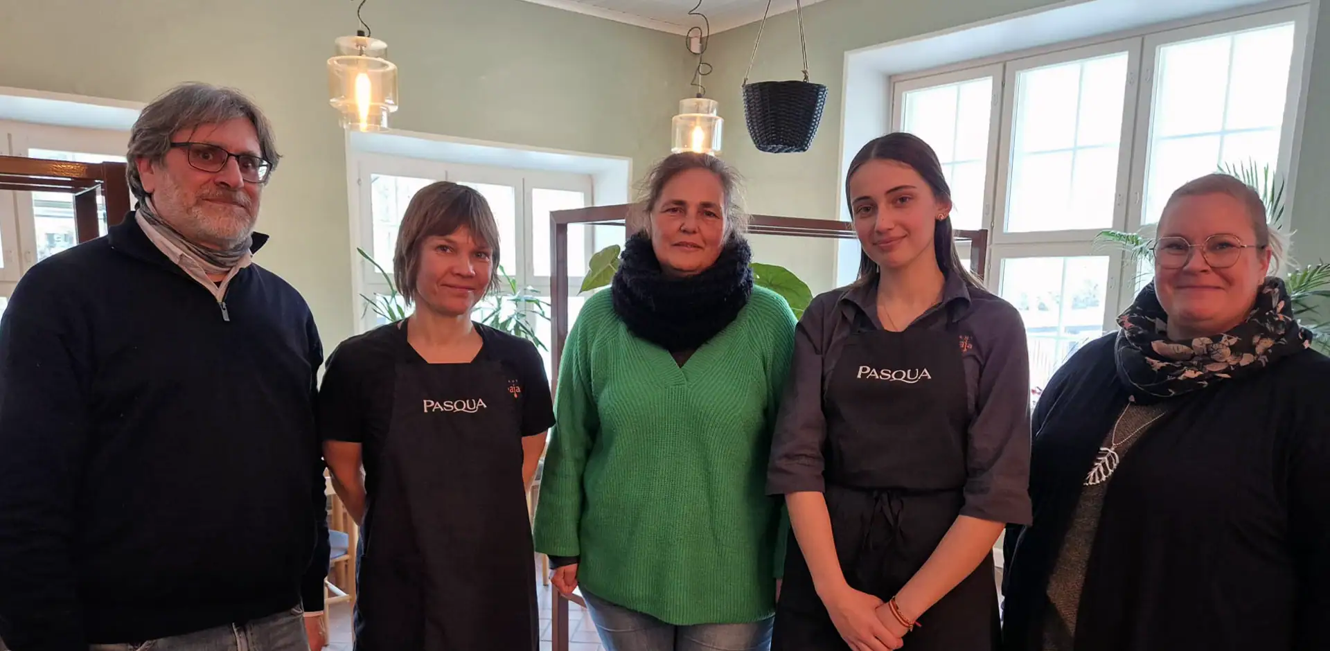 Viisi henkilöä rivissä ravintolan tiloissa.