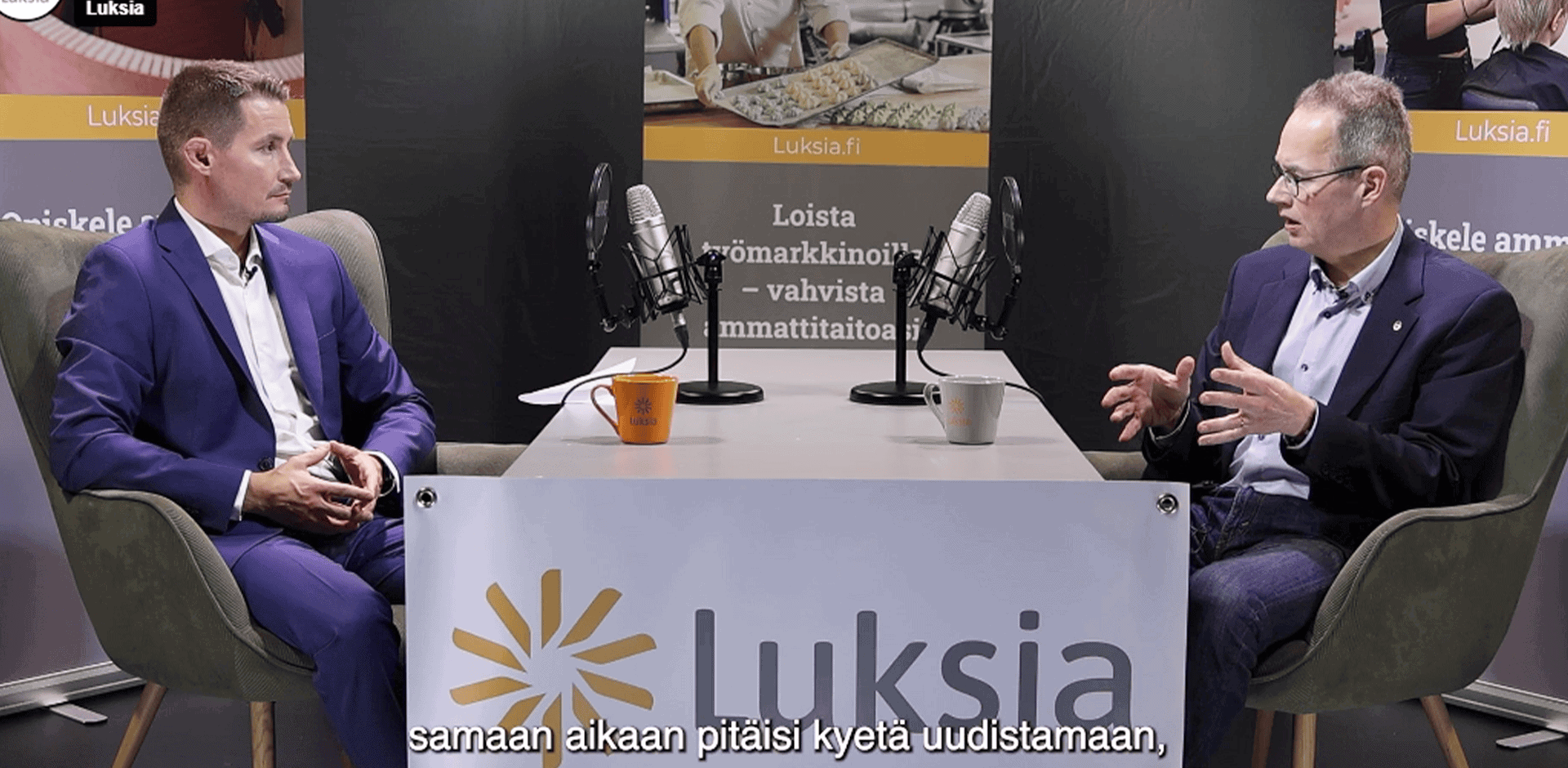 Kaksi henkilöä keskustelee pöydän ääressä.