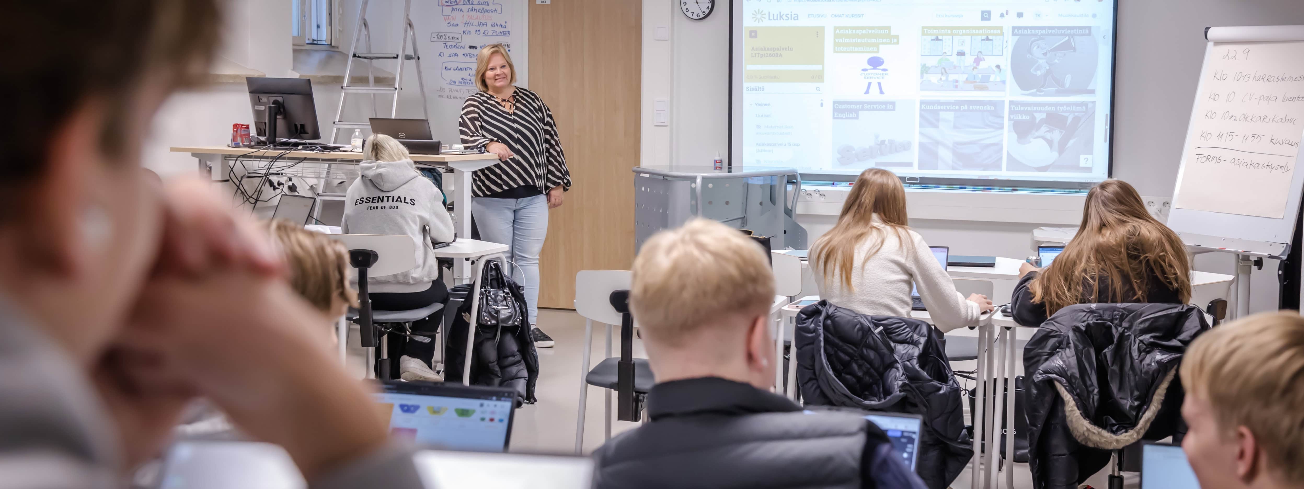 Luksian liiketoiminnan opiskelijat opiskelevat yhdessä luokassa.