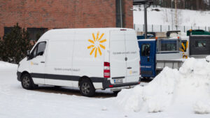 Luksian pakettiauto parkissa lumisella pihalla.