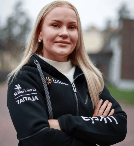 Vaaleahiuksinen henkilö mustassa hupparissa.