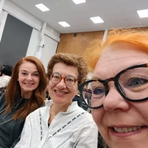 Kolme henkilöä istuu yleisössä