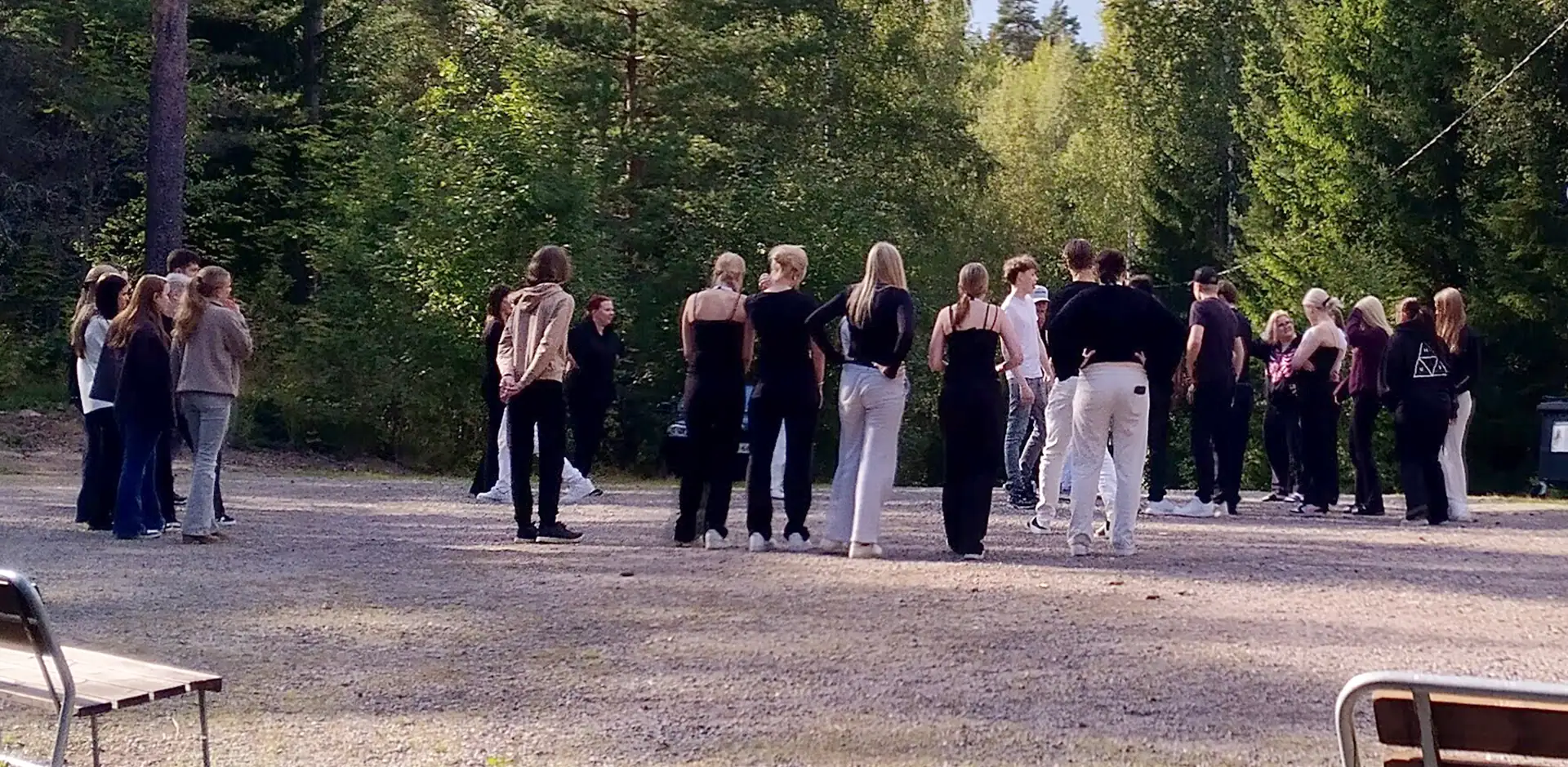 Nuoria kerääntyneenä yhteen mökkipihassa.