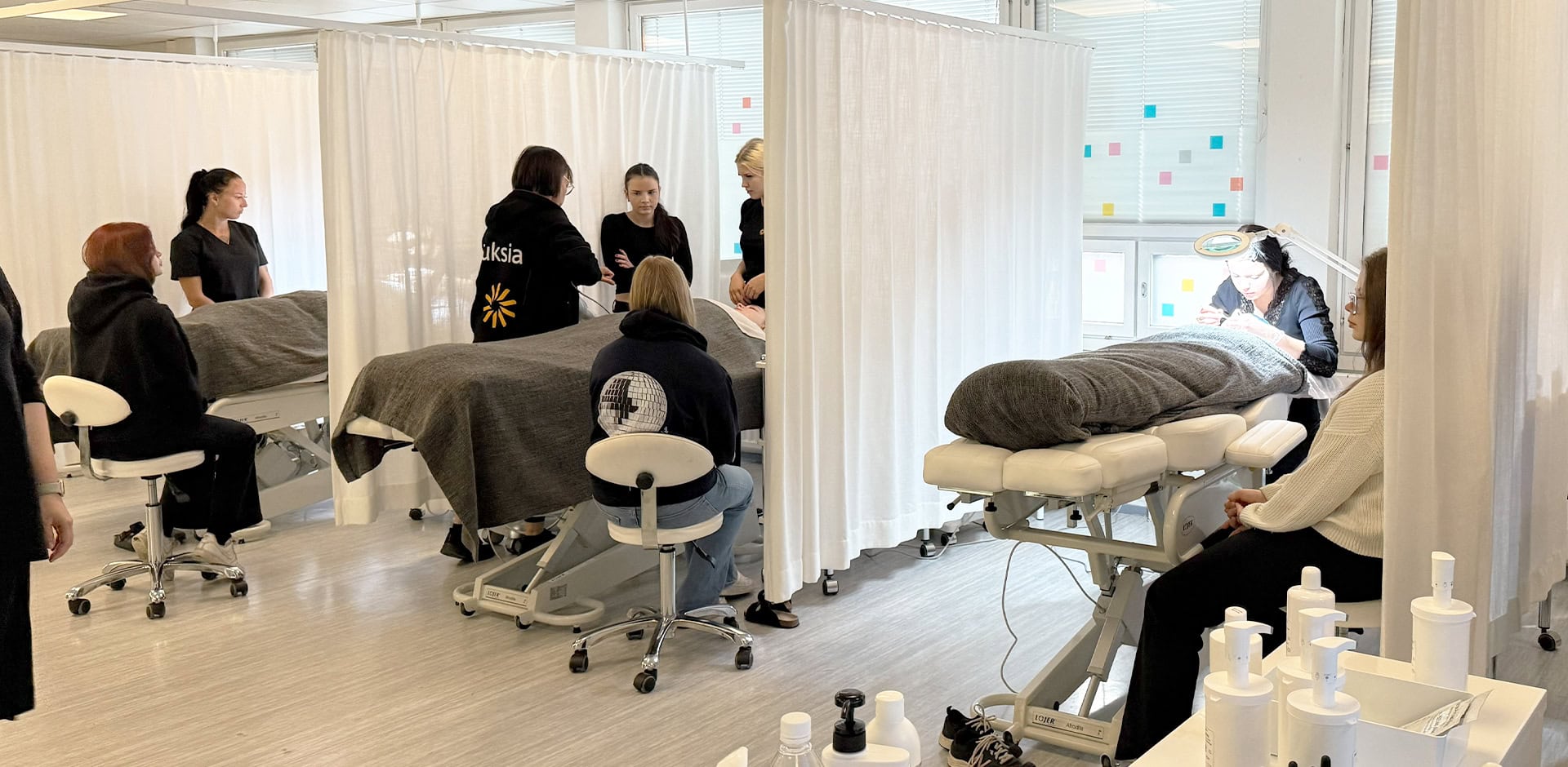 Kauneudenhoitoalan opetustilat, jossa ihmisiä.
