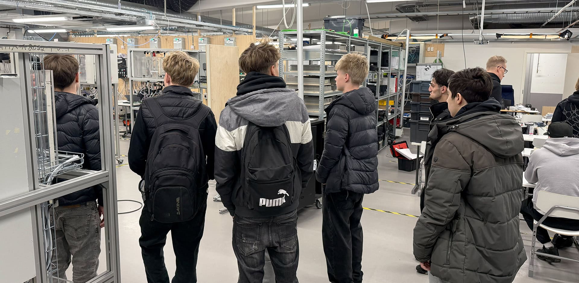 Sähkö- ja automaatioalan opetustilat, jossa ihmisiä.