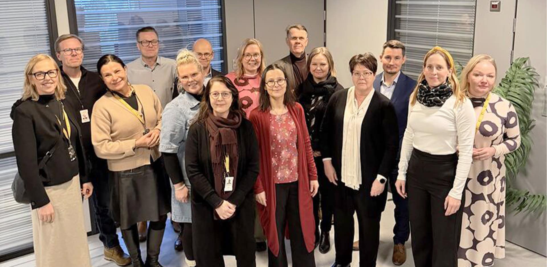 Joukko ihmisiä katsoo kameraan ja hymyilee.