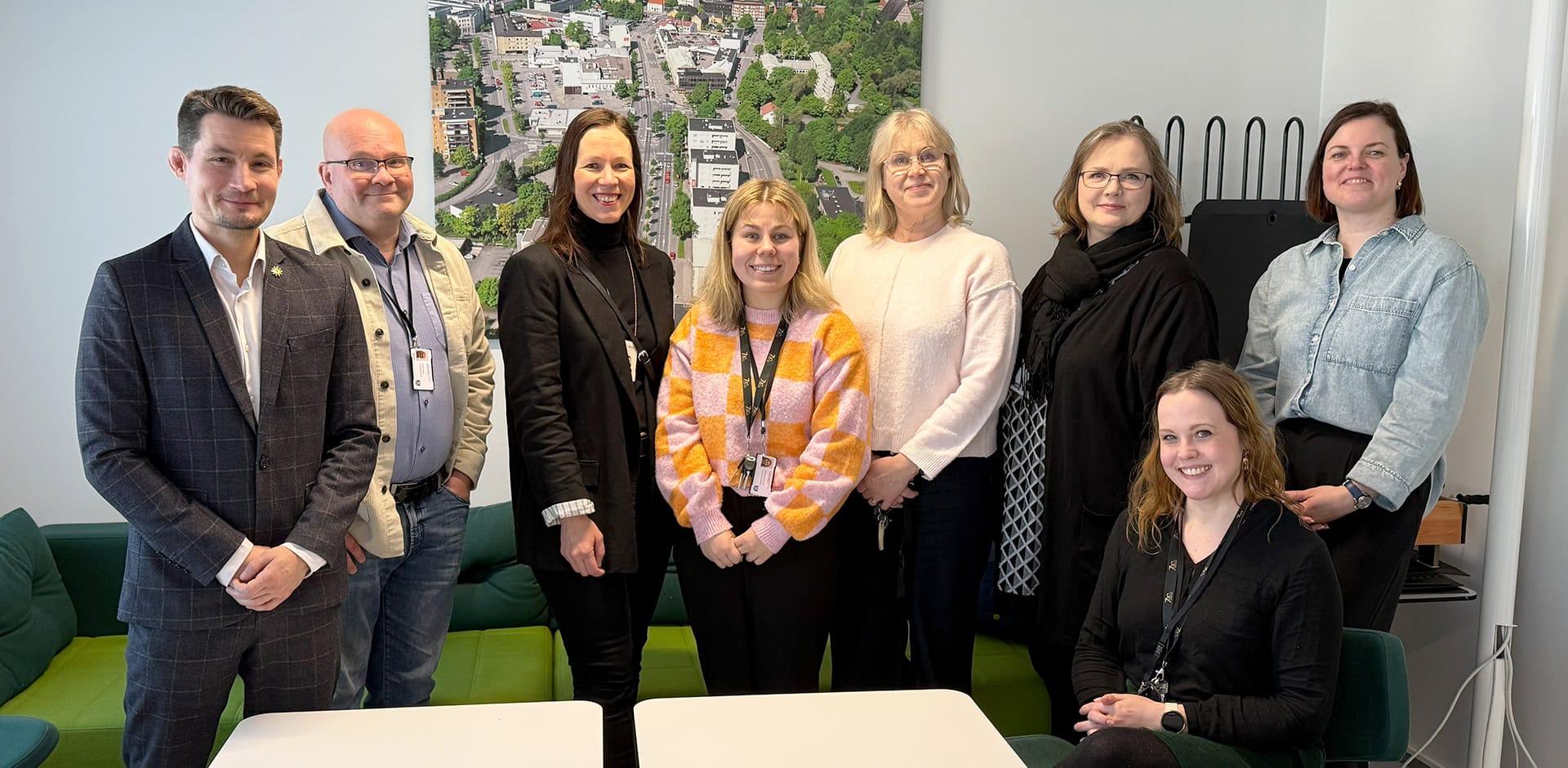 Ryhmä ihmisiä poseeraa kameralle ja hymyilee.